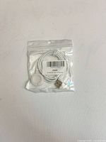 Front view of sealed bag showing cable, magnetic puck, USB-A plug