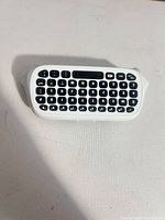 Front view showing full QWERTY key layout and white housing