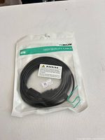 Front of sealed YQMAJIM cable package showing coiled black cable and rectangular connector