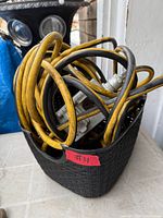 Coiled yellow heavy duty extension cord with black plug and gray tri-tap receptacle