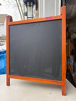 Front view showing black chalkboard surface within wood frame