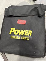 Closed black nylon pouch labeled Power Foldable Shovel