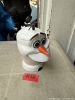 Front angled view of Olaf head mug showing carrot nose, eyes and lid