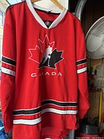 Full frontal view of red Hockey Canada jersey on hanger