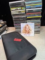 stack of jewel case CDs, one disc wallet closed, loose cover art