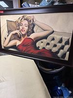 Full view of framed Marilyn Monroe print leaning against surface