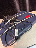 Closed blue Lenovo laptop with AC adapter bundled