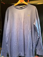 Full view of blue long-sleeve shirt on hanger