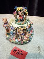 Overall view of painted resin Easter bunnies music box showing figurine details and base