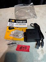 Tracker device, cable, screw, bracket and instructions laid out