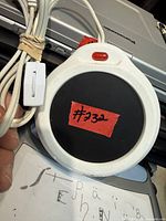 Top view of Salton mug warmer showing black heating surface, red indicator light and attached power cord