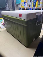 Full view of green Coleman cooler with white lid and latch