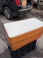 Front and top view of orange cooler with white lid