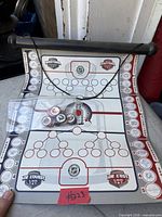overall view of folded-out game board with hanging bar and bag of tokens placed on surface