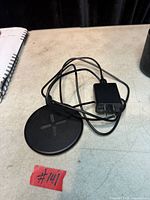 Full view of charging pad, attached cable, and wall adapter on tabletop