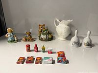 Group shot of all figurines, pitcher, bells and miniature groceries