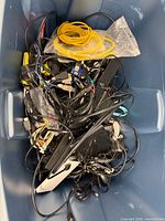 Blue tote showing large quantity of tangled cables and a yellow Ethernet cord on top
