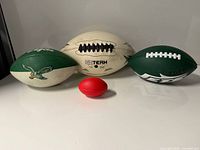 Four footballs displayed: Eagles, Goteam, Jets, red mini