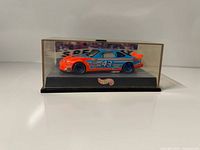 Front view of Hot Wheels #43 STP blue/orange race car in acrylic case