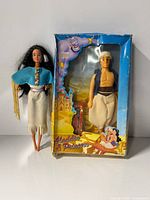 Full view of loose Pocahontas doll beside boxed Aladdin doll set