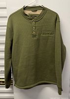 Front view of olive green Stanley waffle-knit sweater on hanger