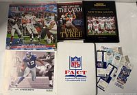 Group shot showing both hardcover books, calendar cover, binder, and ticket stubs