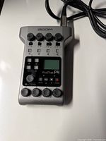 Front view of Zoom PodTrak P4 with knobs, buttons, screen and connected XLR cable visible