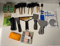 Full lot layout showing sanding sponges, foam brushes, drywall tools, paracord, sponge, organizer and wall patches