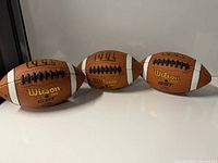 Three footballs side by side showing overall condition and quantity