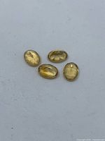Four matching oval citrines on white background