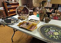 overall view of assorted trays, ceramic ewer, divided dish, platter, baskets and miniatures on table