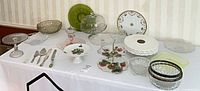 Overall view of assorted glass, crystal, china and steel serveware on table