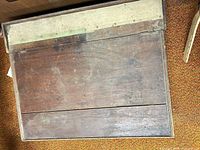 Top view of dark-stained wooden box showing hinged lid and worn finish