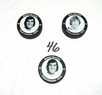 Front view of three pucks showing player portraits Serge Savard (2) and Rod Seiling (1)