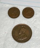 Obverse of three coins showing King George V portrait