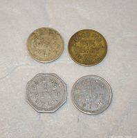 Fronts of four dairy milk tokens showing denomination and shape