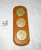 Front view showing three instruments on wooden plaque