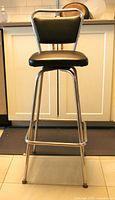 Full view of chrome and black vinyl bar stool