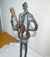 Full rear view of cast iron musician holding guitar