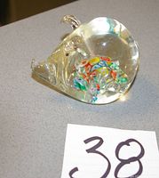 Side view of clear glass pig paperweight showing internal coloured swirls