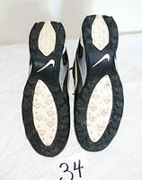 soles of both shoes showing Nike logo and molded rubber studs