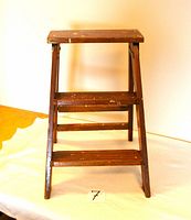 Front view of folding wooden two-step stool