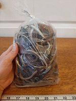 Front view of sealed bag of mixed leather strips with scale
