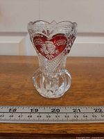 Front view showing ruby flashed heart with etched rose and ruler for scale