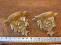 Both gilt plaster wall shelves side by side with ruler for scale