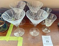 six etched crystal stemware pieces on wooden surface
