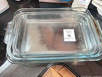 Stacked set of three clear glass baking dishes showing top view and handles