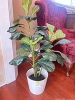 Full view of artificial fiddle leaf fig plant in white ribbed pot