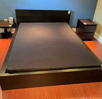 Full view of black platform bed frame with headboard