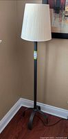 Full view of floor lamp in corner showing shade, pole, and base